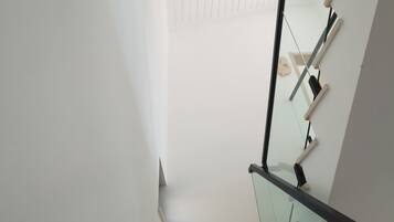 Una escalera moderna con barandillas de cristal y peldaños de madera.