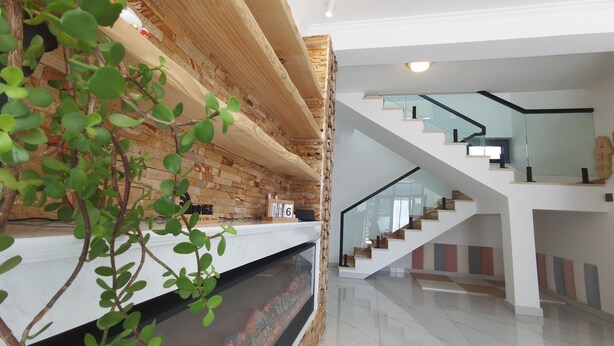 A modern interior with a glass staircase, a fireplace, and a brick wall. - Shanyutianyuan (Huairou)