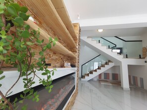 A modern interior with a glass staircase, a fireplace, and a brick wall. - Shanyutianyuan (Huairou)