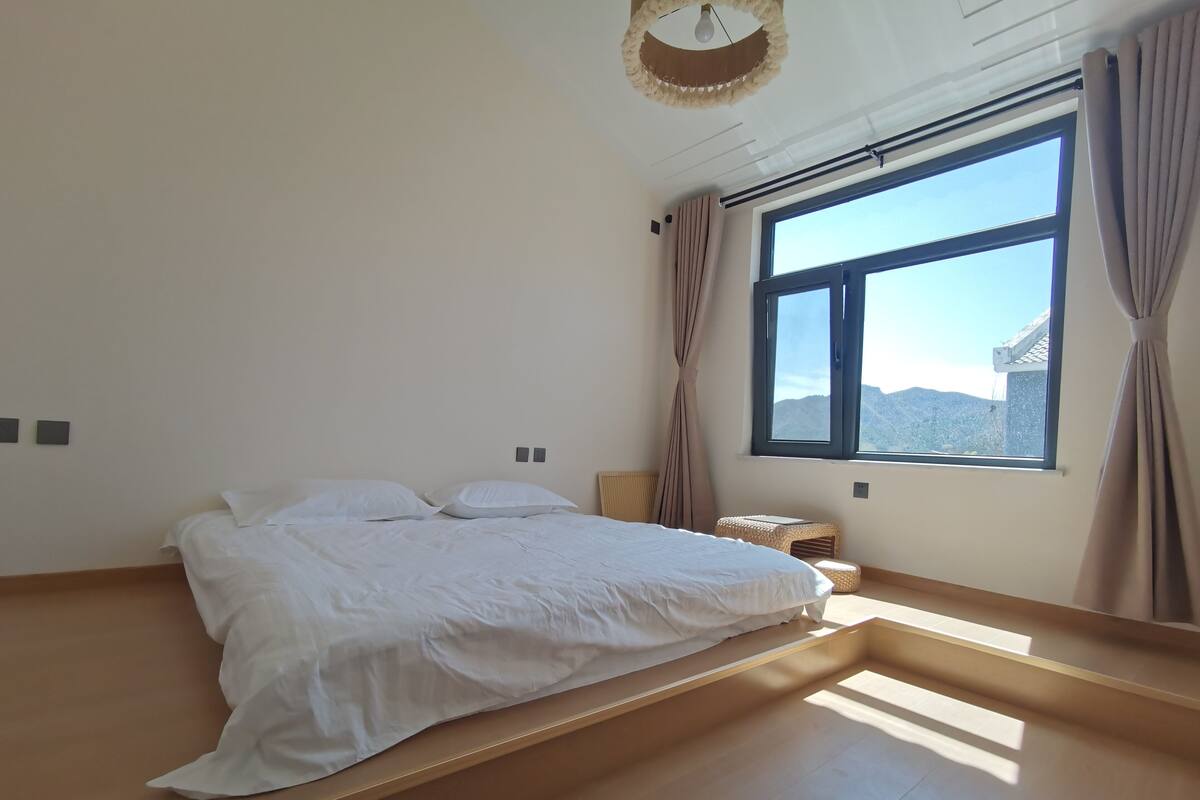 Une chambre à coucher avec un lit, une fenêtre et une vue sur l’extérieur.