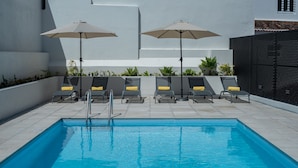 A swimming pool with lounge chairs and umbrellas. - Olive Boutique Guesthouse  (Vila Franca do Campo)