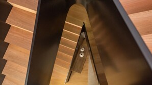 A modern staircase with a sleek black and wood design, leading to an upper floor. - Olive Boutique Guesthouse  (Vila Franca do Campo)