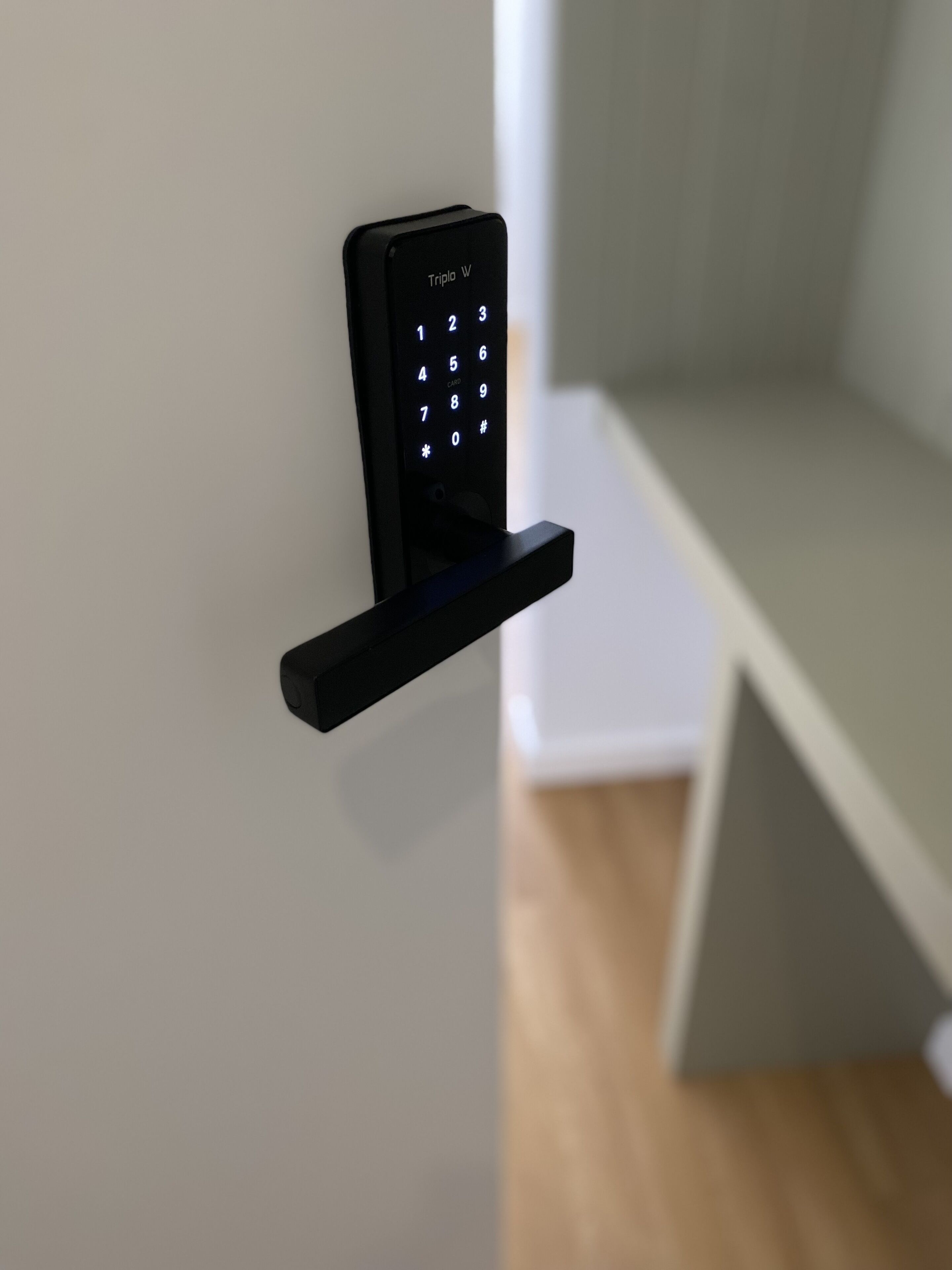A black electronic keypad mounted on a wall, likely for a door lock.