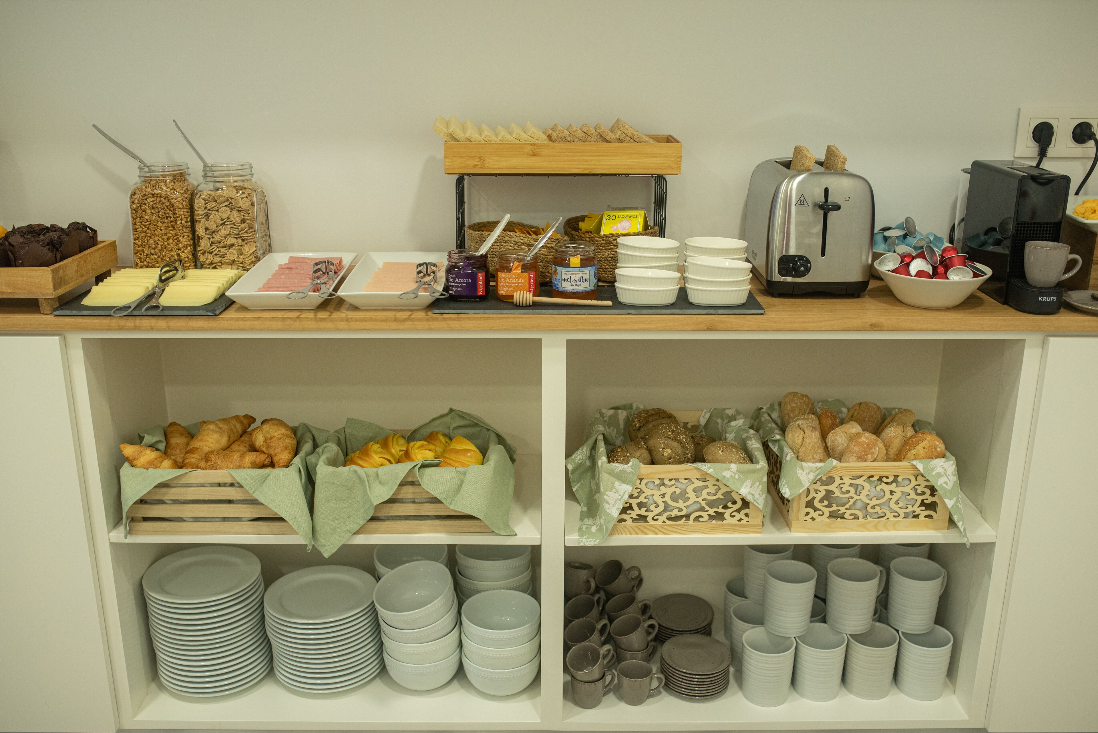 A breakfast buffet with various food items, utensils, and a toaster.