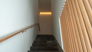 A staircase with dark stone steps and a wooden handrail. - Olive Boutique Guesthouse  (Vila Franca do Campo)