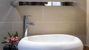 A bathroom with a white sink, a mirror, and a towel rack. - Havana Apartment - Panoramic view with pool (Jan Thiel)