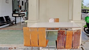 A room with a table, chairs, and a motorcycle outside. - Hotel O Aulia Homestay Syariah (Batam)