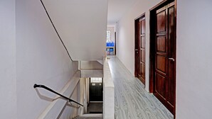 A narrow hallway with a wooden door labeled "203" and a staircase with a handrail. - Hotel O Aulia Homestay Syariah (Batam)