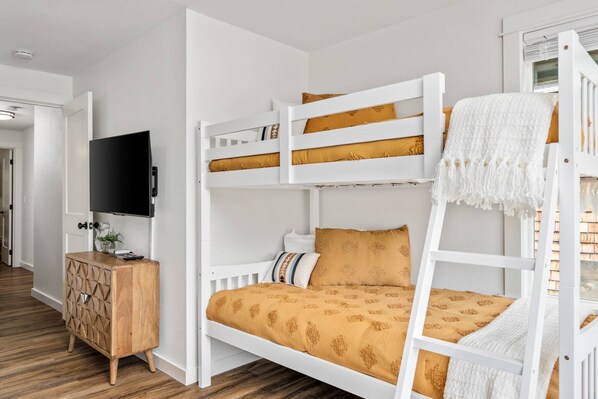 A bunk bed room with a TV, wooden cabinet, and a white wall. - Impeccable Custom Furnishing and Design, Pet Friendly, BBQ, One Block From Center of Government Camp (Government Camp)