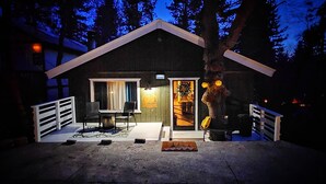Une petite cabane moderne dotée d’un coin repas et d’une enseigne bien visible indiquant : « Le Nid du Hibou ».