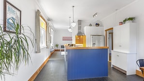 A modern kitchen with a central island, white cabinetry, and pendant lighting. - Spacious, Welcoming, and Secure (Hamilton)