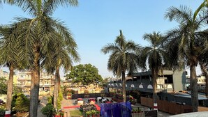Un patio con palmeras, un escenario y asientos al aire libre.