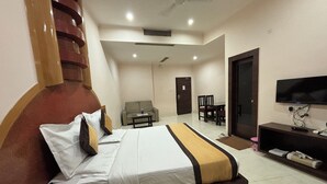A hotel room with a bed, a television, a desk, and a sofa. - Hotel Akanksha (Jagdalpur)