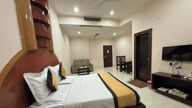 Una habitación de hotel con una cama, televisor, escritorio y sofá.