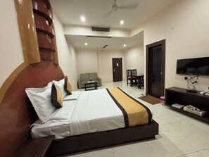 A hotel room with a bed, a television, a desk, and a sofa. - Hotel Akanksha (Jagdalpur)