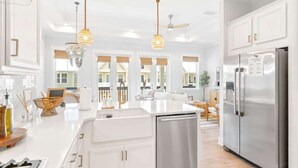 A modern kitchen with white cabinetry, stainless steel appliances, and pendant lighting. - Watersound Escape by Stay on 30a (Inlet Beach)