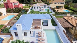 A modern house with a swimming pool, a covered patio, and a well-maintained garden. - Villa Petra in Afrato (Kefalonia)