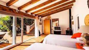 A room with two beds, a TV, and a view of the outdoor area. - Villa 'Luxury Xenofilia Lll' with Mountain View, Wi-Fi and Air Conditioning (Moraira)