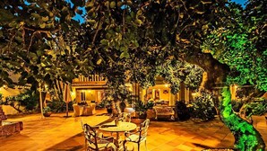 An outdoor patio area with a dining table and chairs, surrounded by potted plants and a stone pathway. - Villa 'Luxury Xenofilia Lll' with Mountain View, Wi-Fi and Air Conditioning (Moraira)