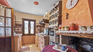 Eine Küche mit Mikrowelle, Toaster und verschiedenen Küchenutensilien in Regalen.