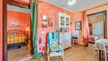 Una habitación con cama, una silla de ruedas, un armario, una mesa y una silla.