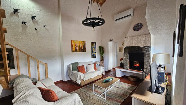 Una sala de estar con chimenea, un sofá, una mesa de centro y un televisor.