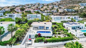 A residential area with modern houses, a swimming pool, and a hillside backdrop. - Villa "Modern Seaview" with Private Pool & Wi-Fi (Benitachell)