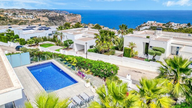 A rooftop pool with a view of the sea, surrounded by greenery and modern buildings. - Villa "Modern Seaview" with Private Pool & Wi-Fi (Benitachell)