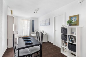 Un salon moderne comprenant une table à manger, des chaises, un canapé et une bibliothèque.