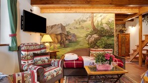 Una sala de estar acogedora con un mural, muebles de madera y un televisor de pantalla plana.