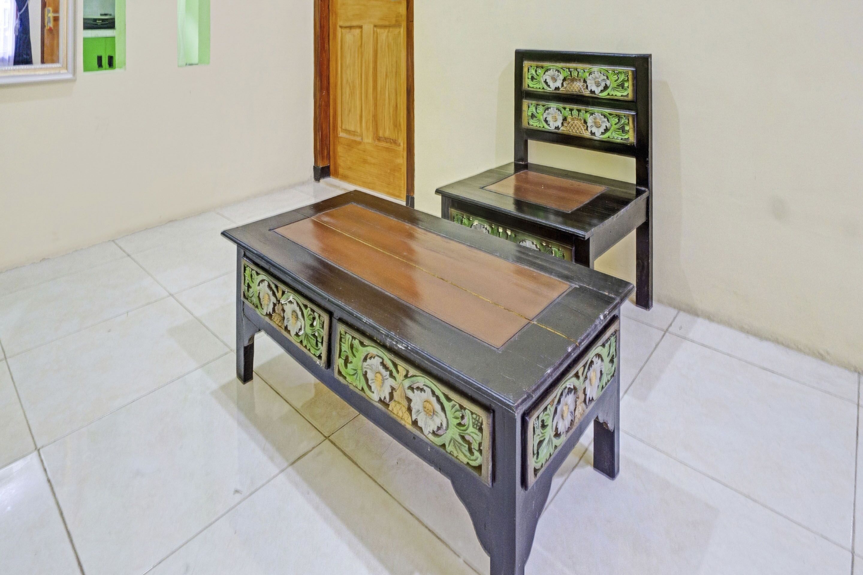 A room with a wooden table and a matching chair, both with intricate designs.