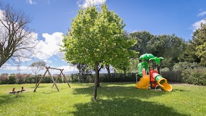 A playground with swings, a slide, and a climbing structure.