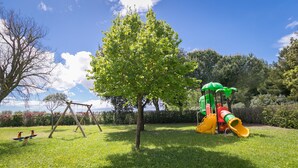 Un parque infantil con columpios, tobogán y estructura para escalar.