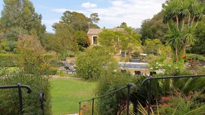 Un jardín con una escalera de piedra que lleva a una casa de techo con tejas.