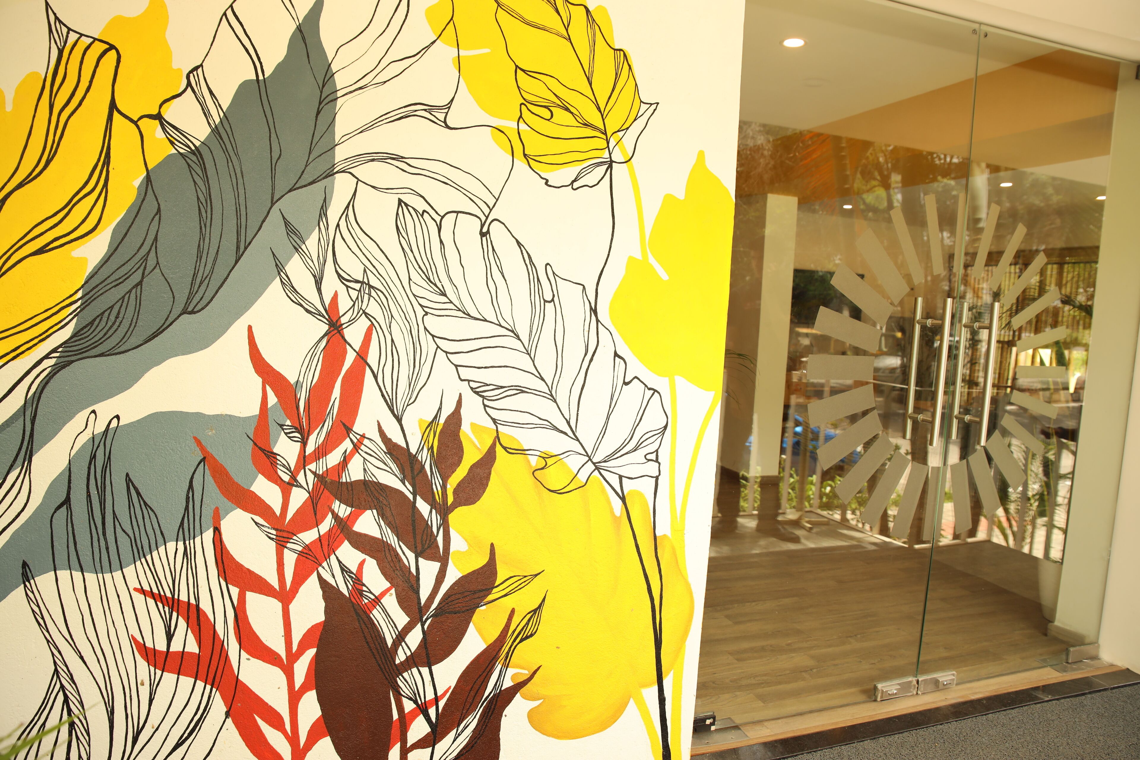 A modern interior with a large abstract art piece on the wall and a unique glass door design.