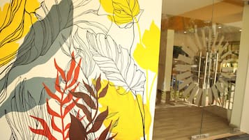 A modern interior with a large abstract art piece on the wall and a unique glass door design.