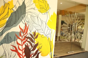 A modern interior with a large abstract art piece on the wall and a unique glass door design.