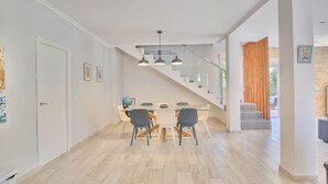 A modern dining area with a staircase leading to a loft. - Modern villa in Las Rotas with air conditioning (Denia)