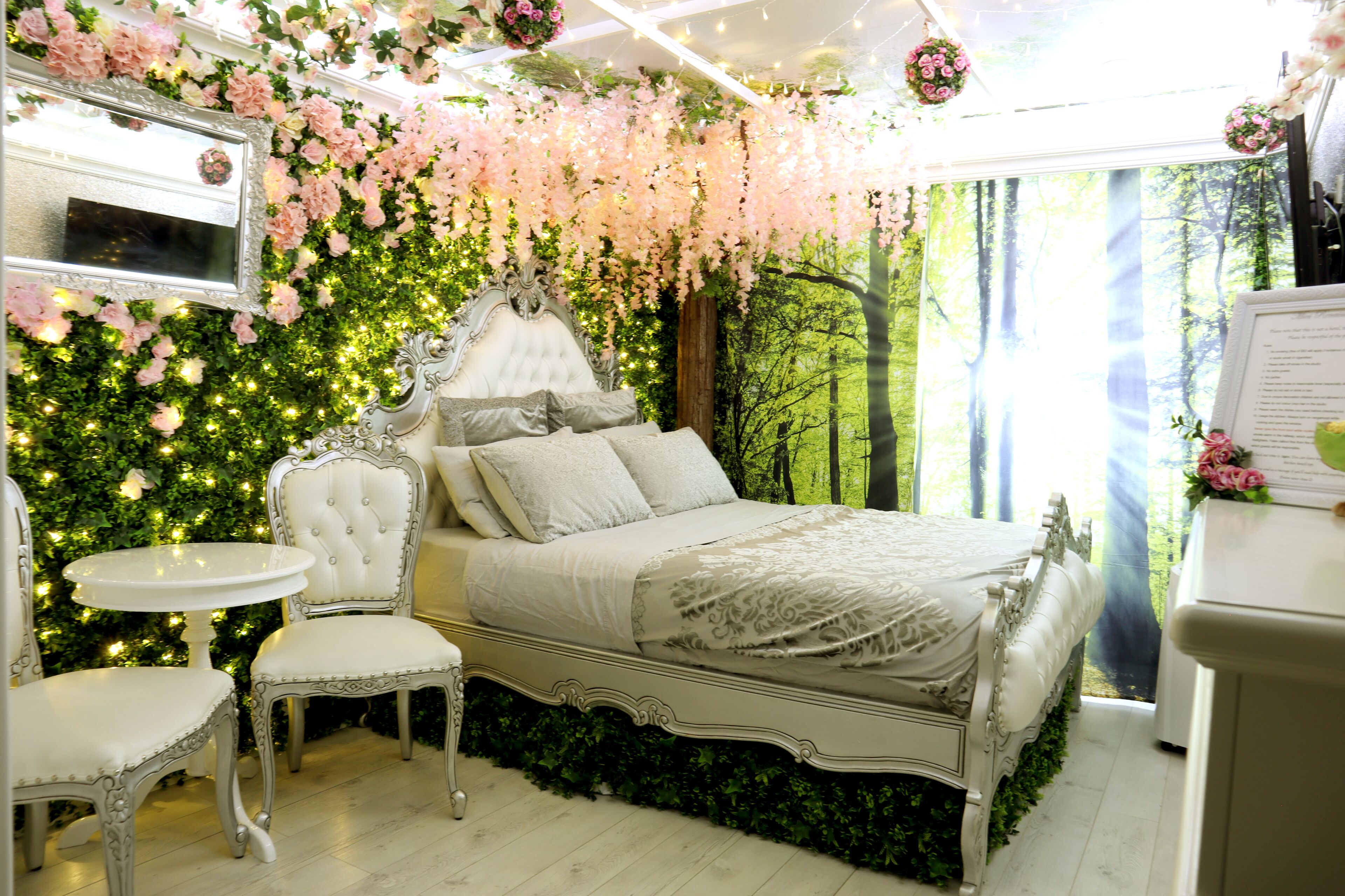 Quarto com cama, cadeira, mesa e espelho.