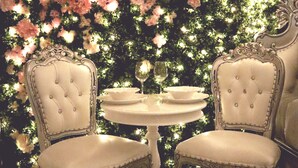 A table with two chairs, surrounded by a floral backdrop. - Secret Garden - A Magical Themed Studio in the heart of Melbourne CBD (Melbourne,)