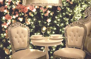 Enjoy a formal dining experience with a round table and classic chairs, set with fine china and a beautiful floral arrangement.