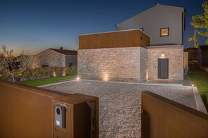 Un edificio moderno con fachada de piedra, techo plano y una entrada bien iluminada.