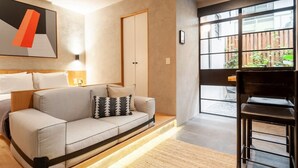 A modern living room with a sofa, a coffee table, and a large window with a view of greenery outside. - Beautiful apt w/ terrace @Parque Mexico | ChiCo (Ciudad de México)