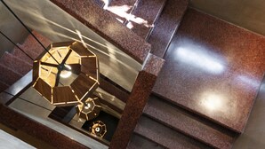 A modern staircase with a geometric light fixture at the top.