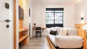 Una habitación pequeña con una cama, un escritorio y una silla.