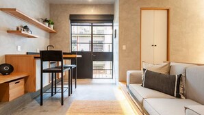 A compact living space with a kitchenette, a dining area, and a seating area with a sofa and a chair. - Wonderful apt w/ balcony @Parque Mexico | ChiCo (Ciudad de México)