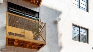 A modern building with a wooden balcony, a garage door, and a concrete entrance. - Wonderful apt w/ balcony @Parque Mexico | ChiCo (Ciudad de México)
