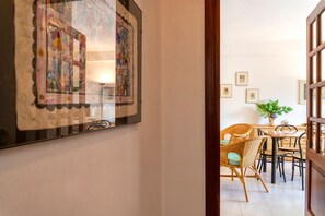A dining area with wicker chairs, a table, and a potted plant.