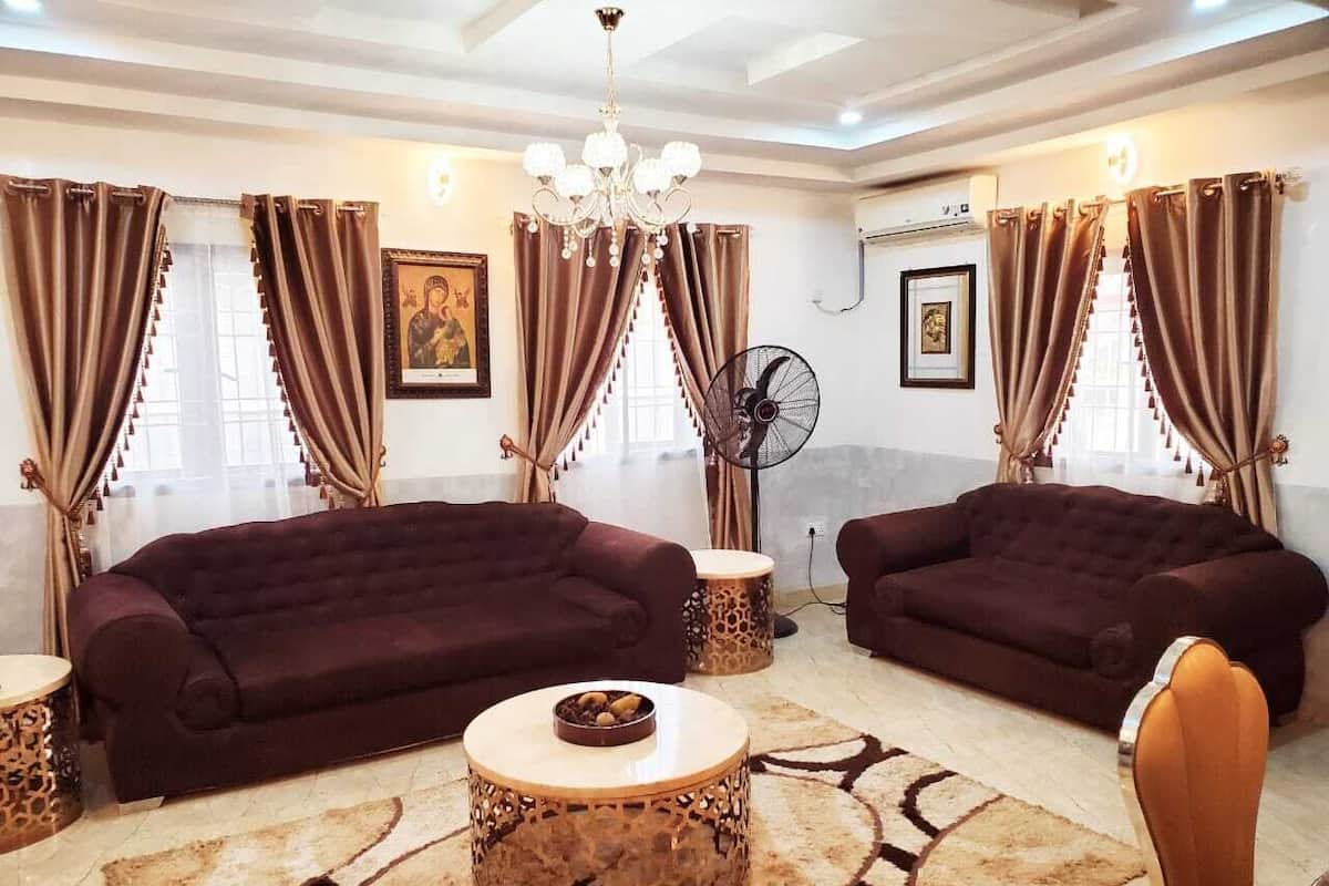 A living room with two dark sofas, a round coffee table, and a patterned rug.