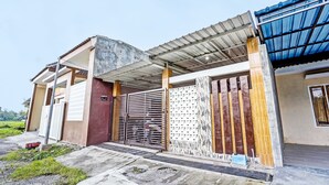 A building with a gated entrance, a covered porch, and a blue roof. - Hotel O Sobat Ijen HomestayNearSungai Prengsengan (Rogojampi)